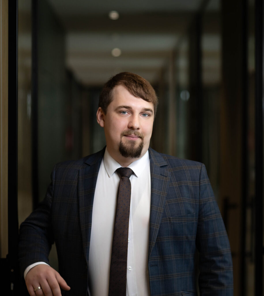 Obraz przedstawia radcę prawnego Mateusza Białomyzego na tle kancelarii.